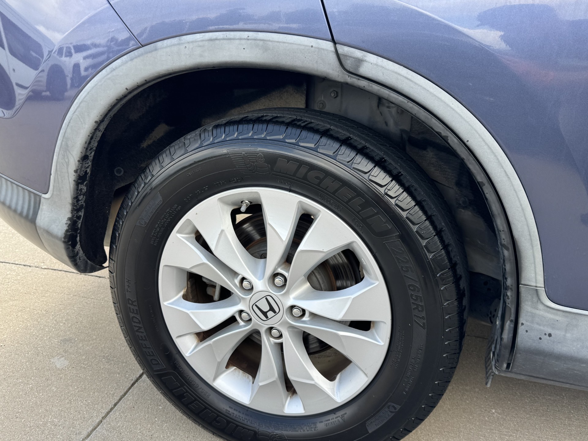 Before photo of faded rear fender flare on blue Honda CR-V
