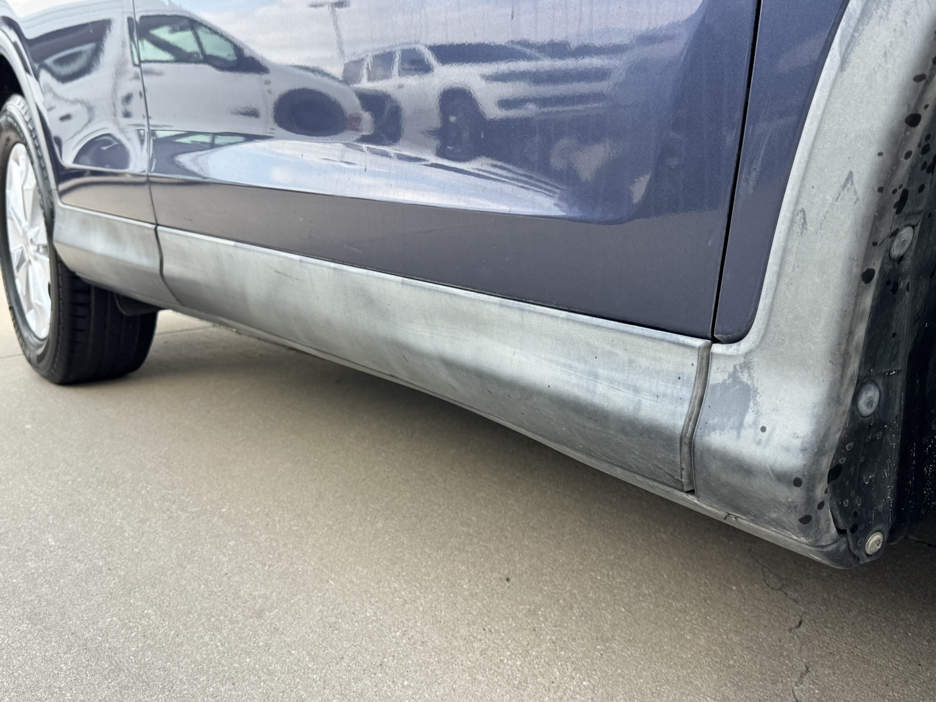Before photo of oxidized gray rocker panel cladding
